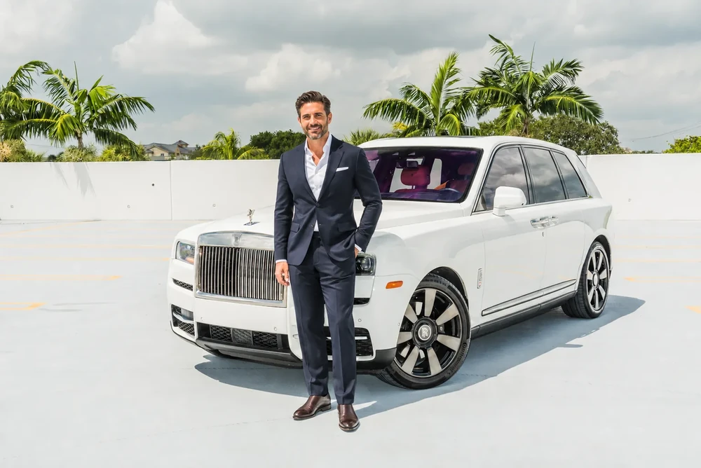 Homem em pé ao lado de um Rolls-Royce Cullinan branco